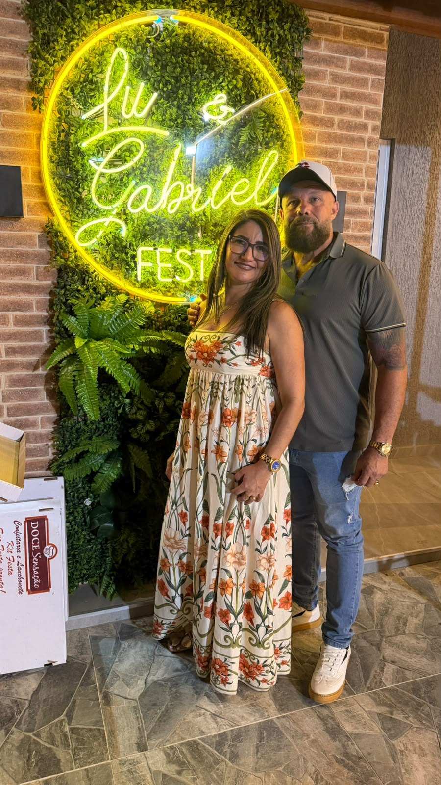 Casal posando em frente ao painel neon Lu & Gabriel Festa
