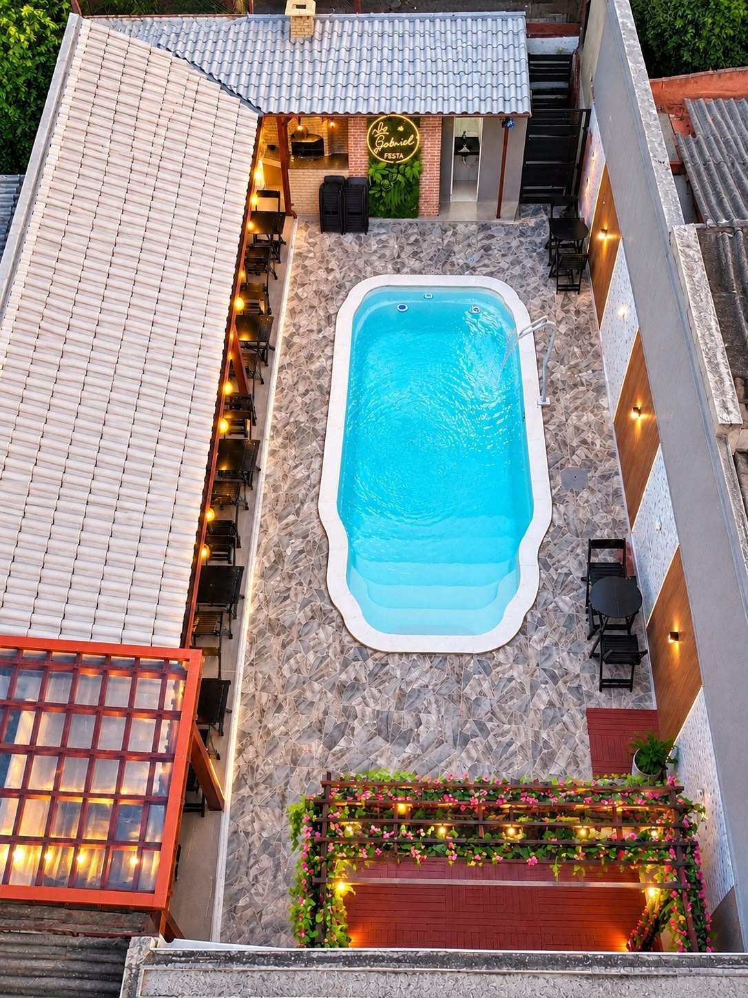 Vista aérea da piscina do espaço Lu & Gabriel Festa, com a área coberta e o pergolado